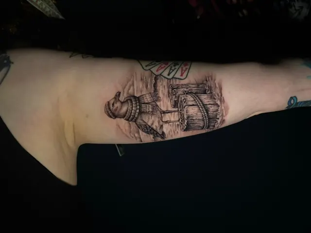 Micro-realism arm tattoo with four aces and a wooden crate